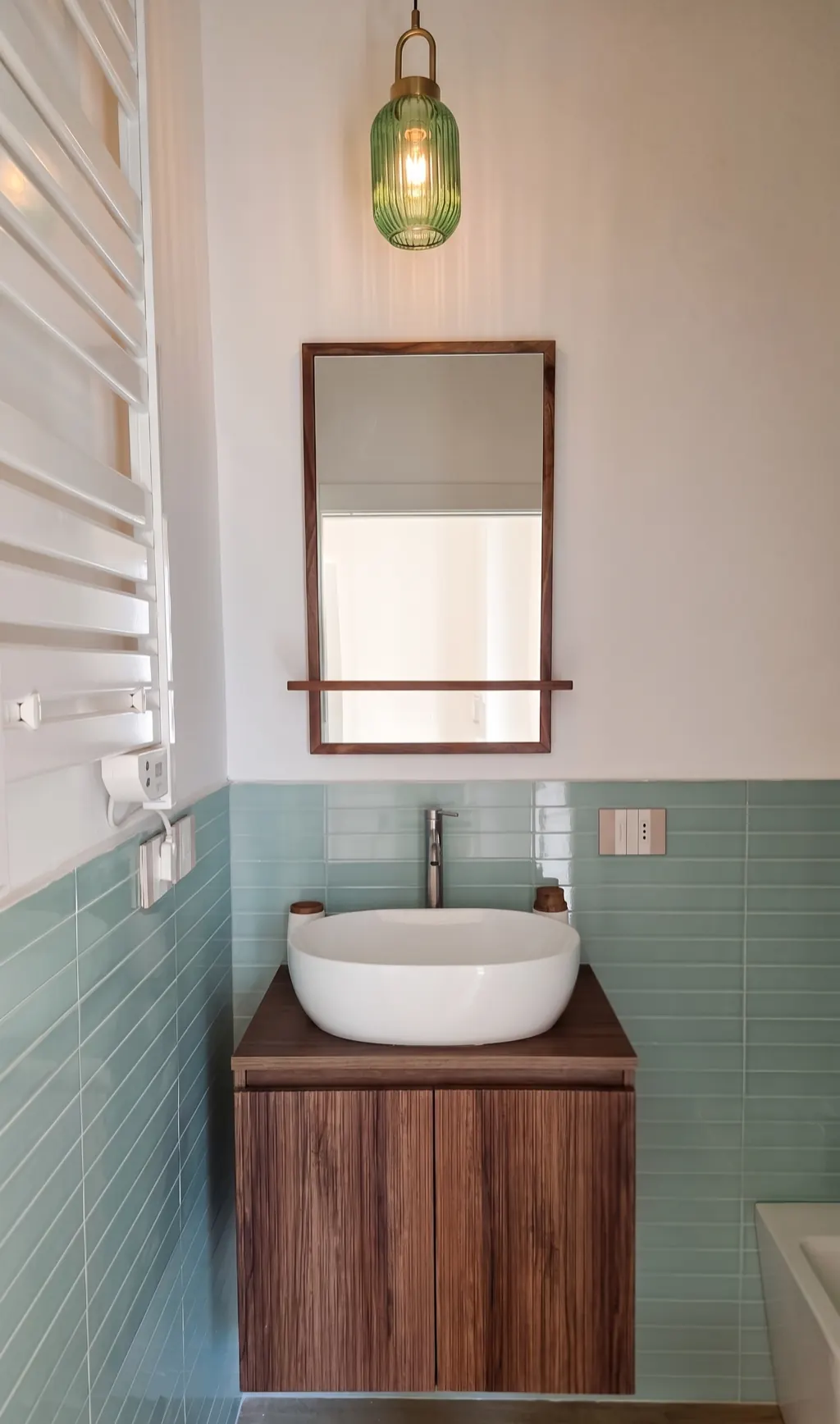 Lavabo con mobile in legno, specchio e lampada di vetro verde